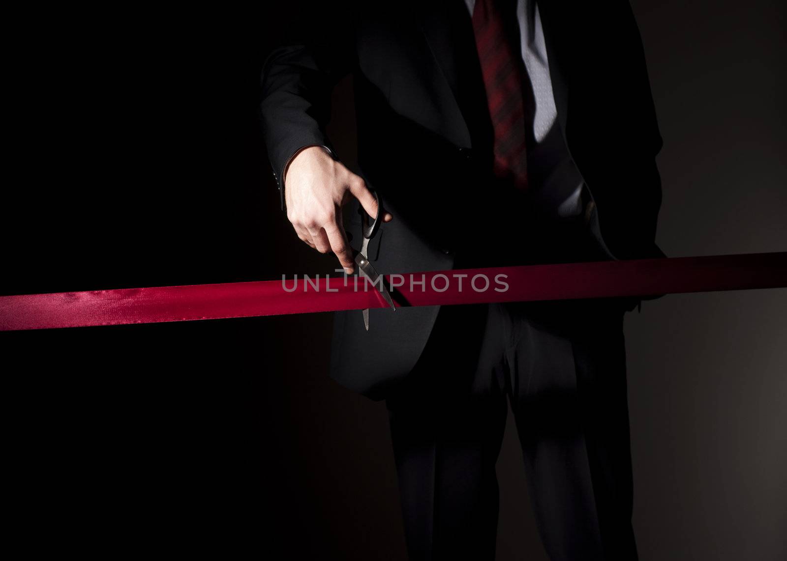 man in a suit, cuts a red tape, opening of event