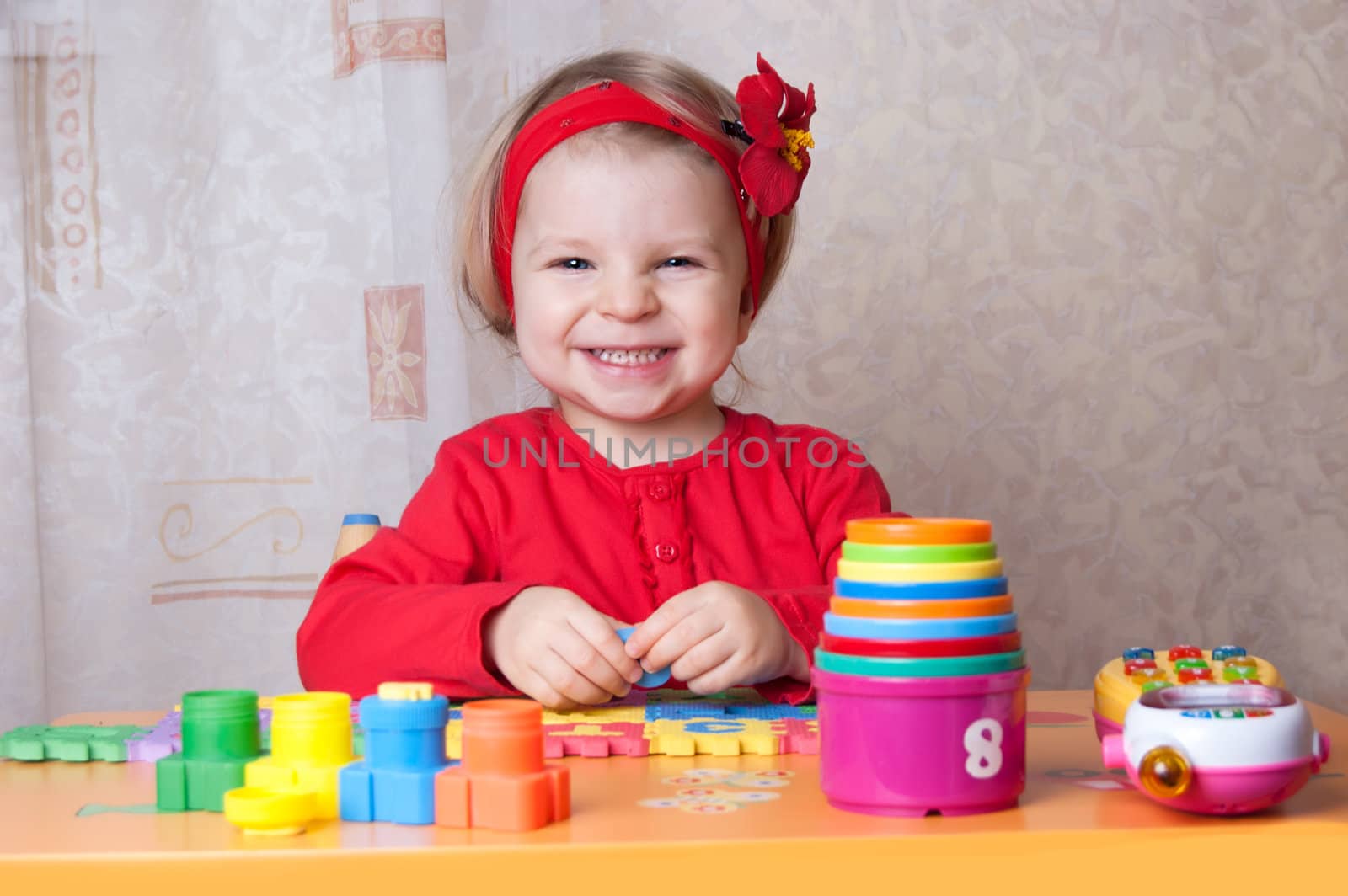 Smiling girl playing at table in nursery