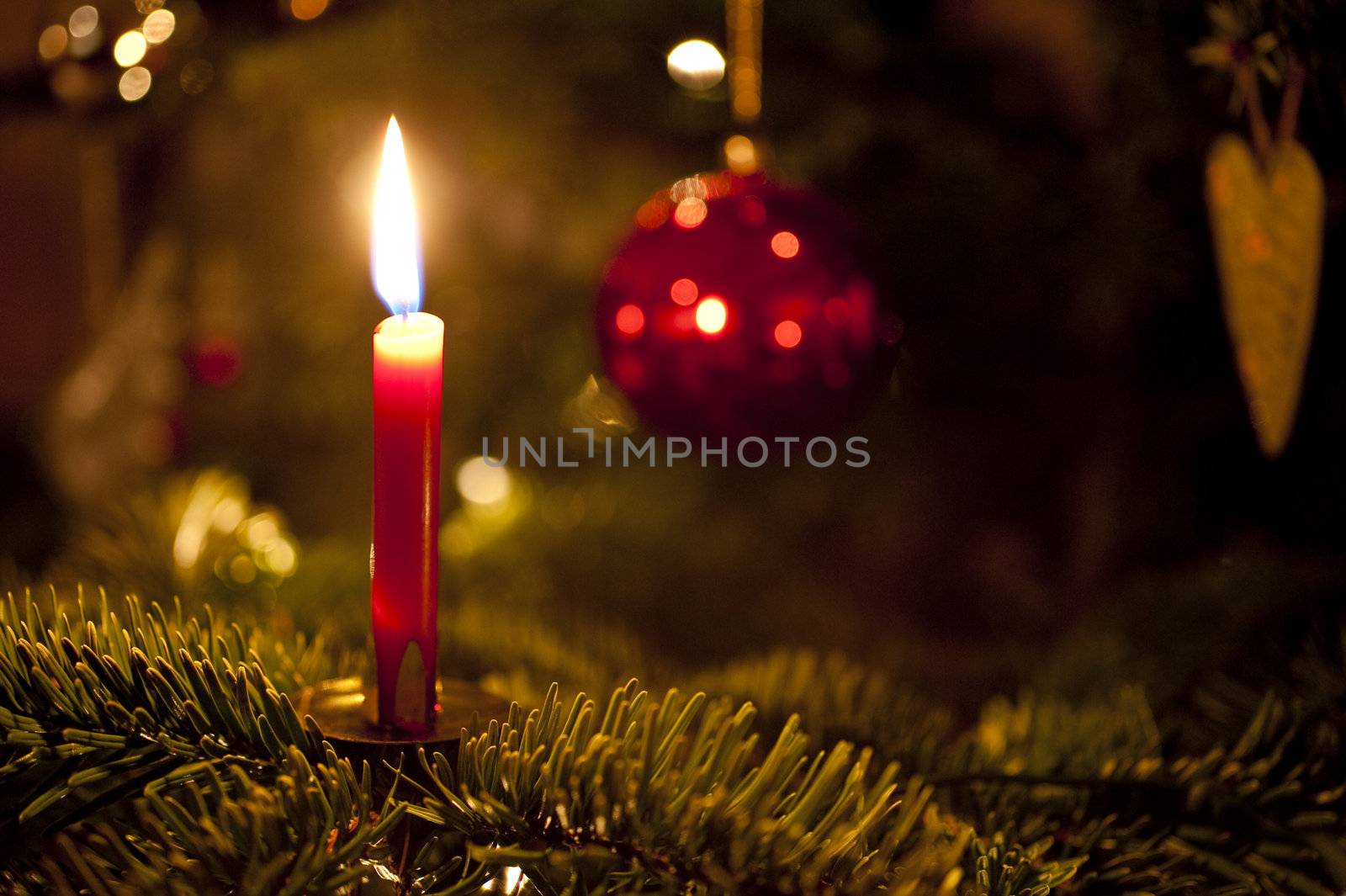 close up of a candle on a christmas tree