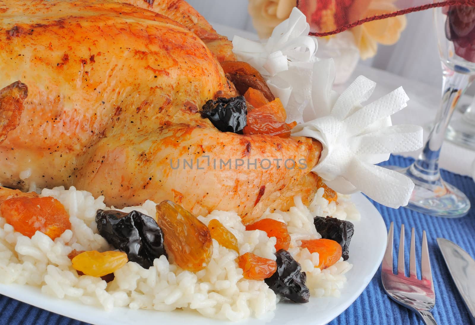 A fragment of grilled chicken with rice and dried fruits closeup
