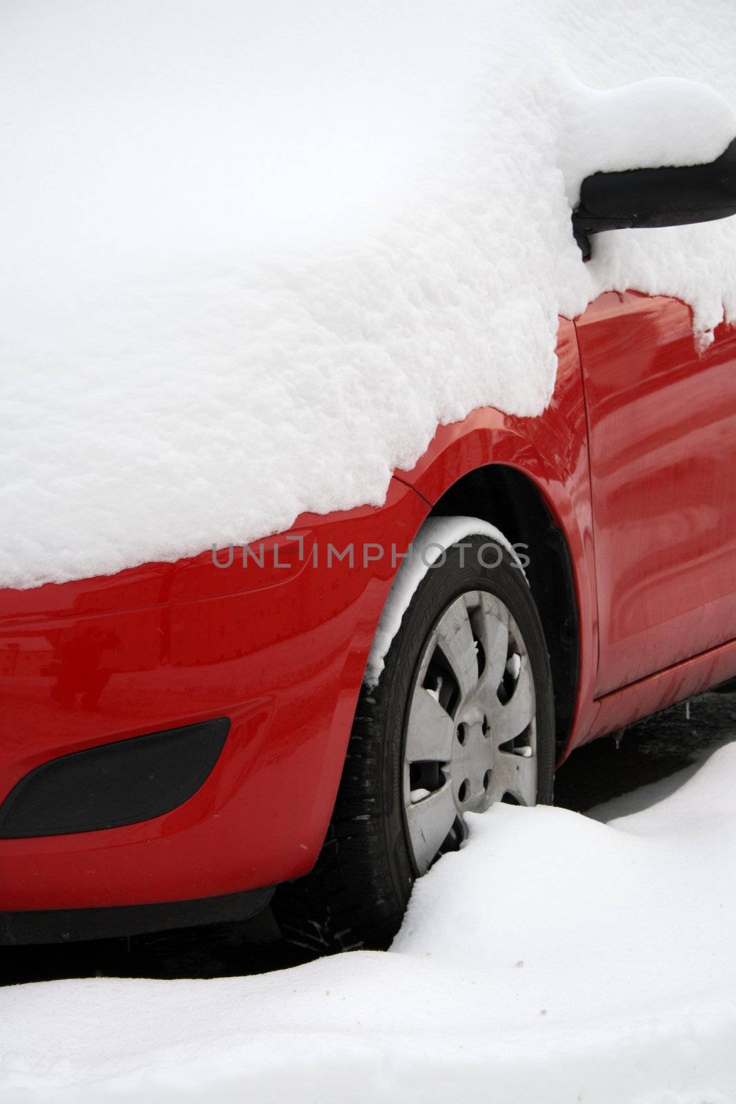 red car covered with snow in winter  by photochecker