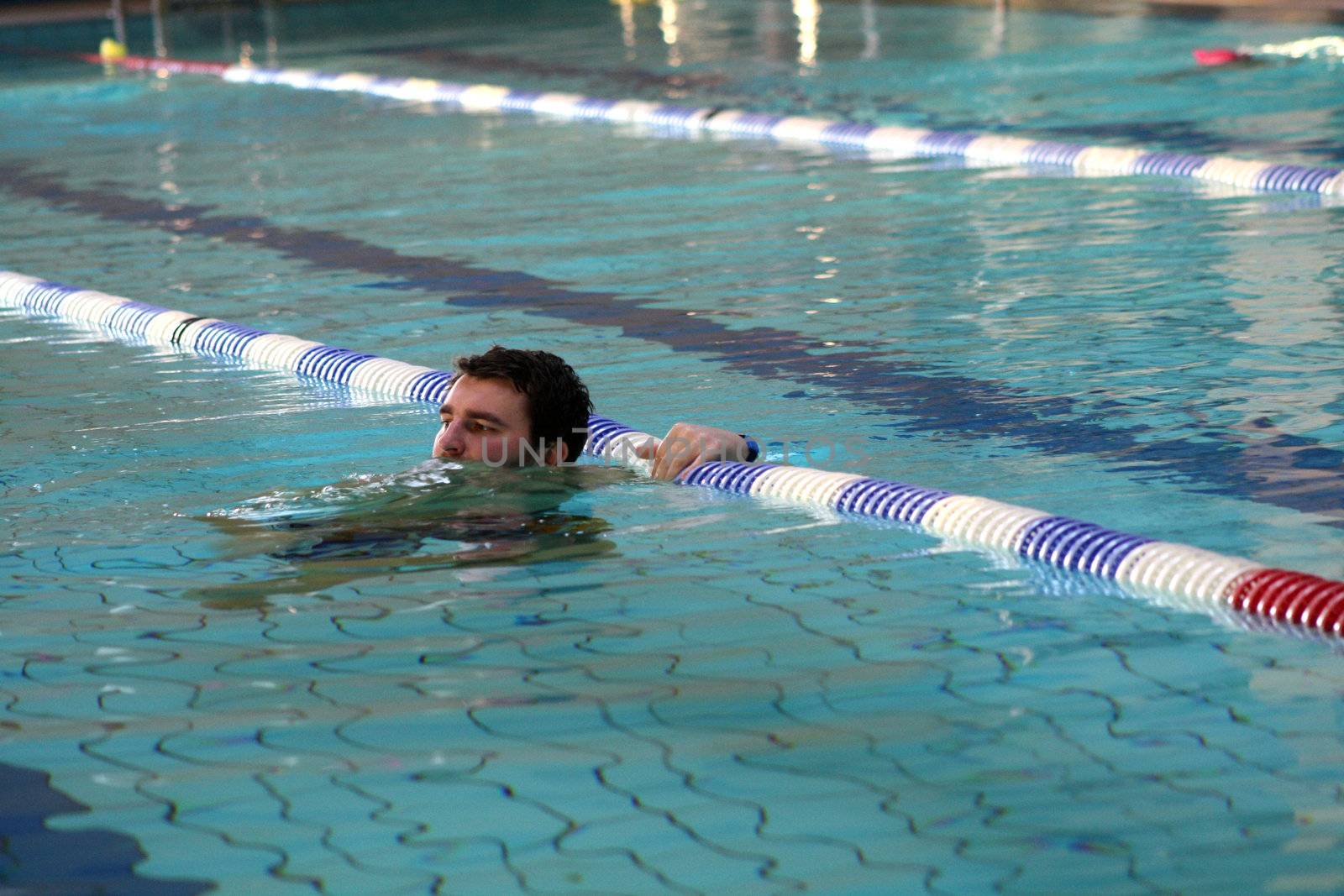 man swims in swimming pool