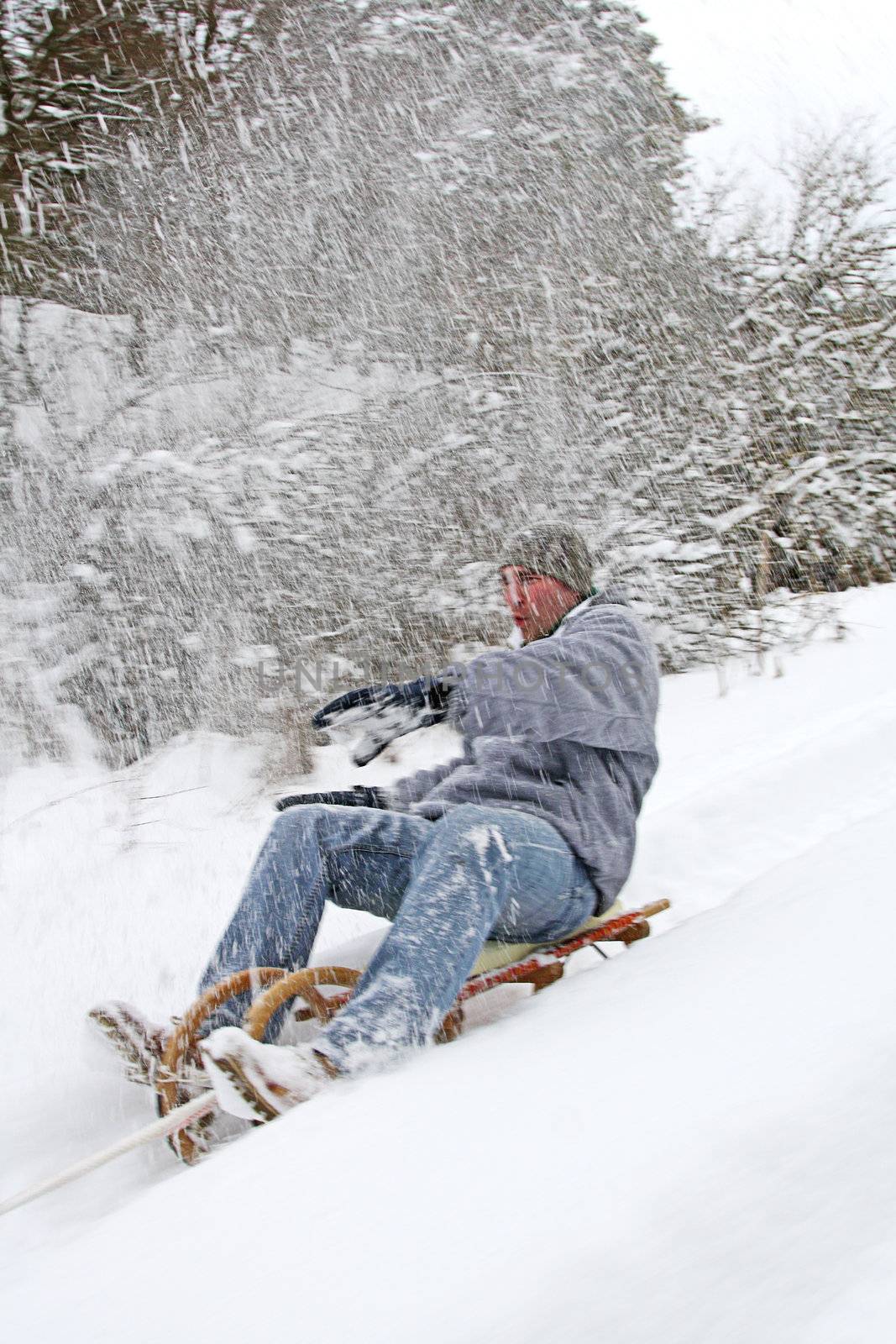 young man goes sleigh in winter by photochecker