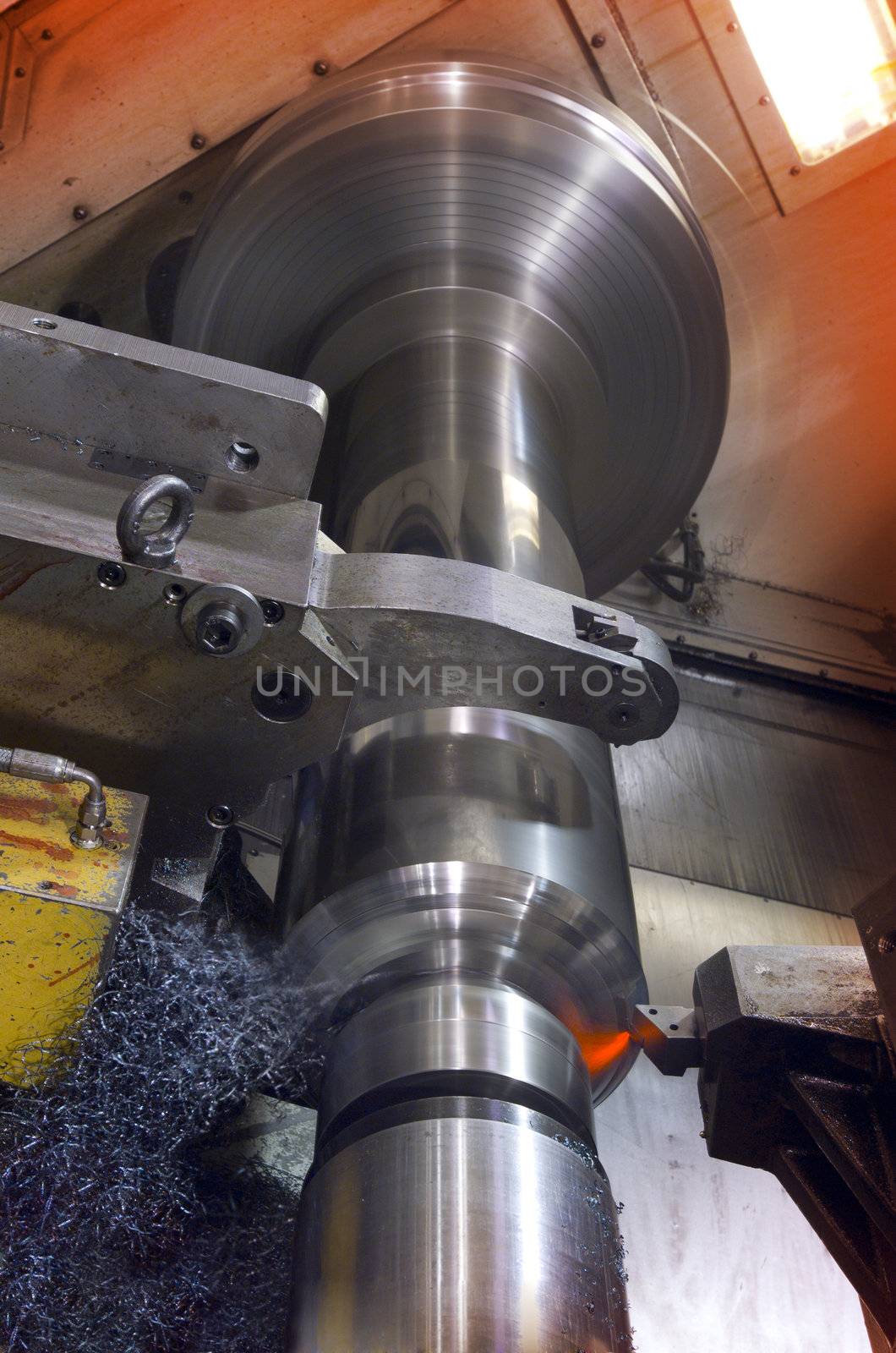 Big industrial lathe cutting through a steel tube
