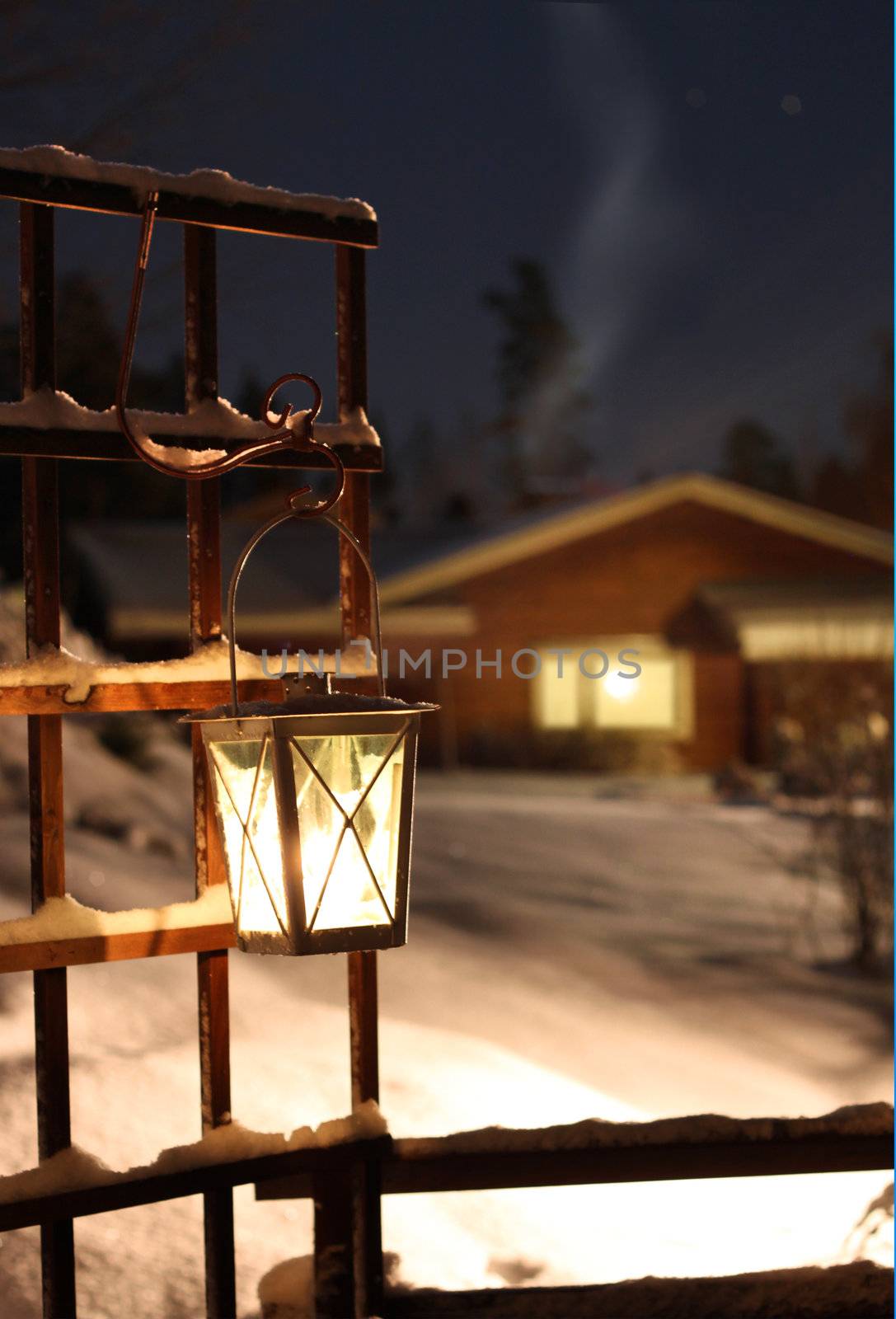 Candle lantern hanging, snowy winter evening twilight