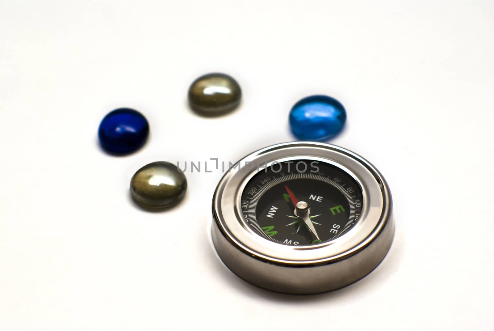 Compass whit colored stones on white background