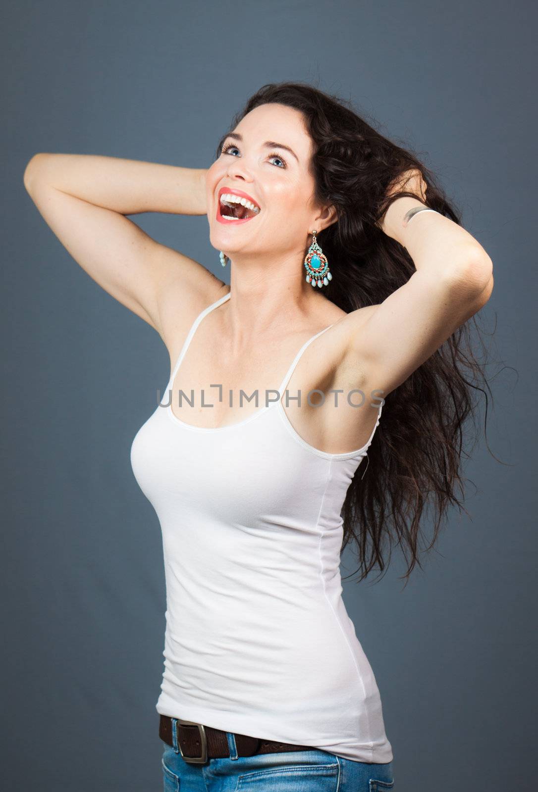 A beautiful young woman laughing and touching her hair