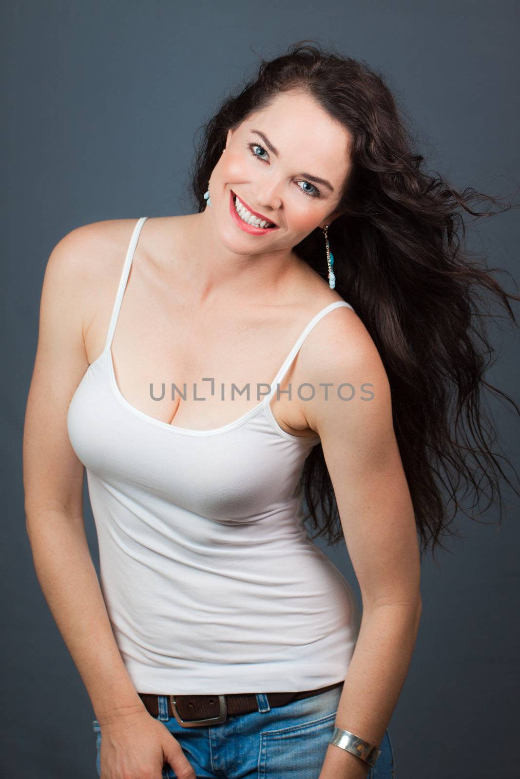 Portrait of a happy beautiful young woman, over grey background