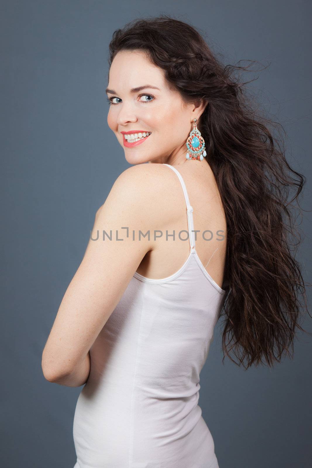 Portrait of a beautiful young woman smiling and looking over her shoulder