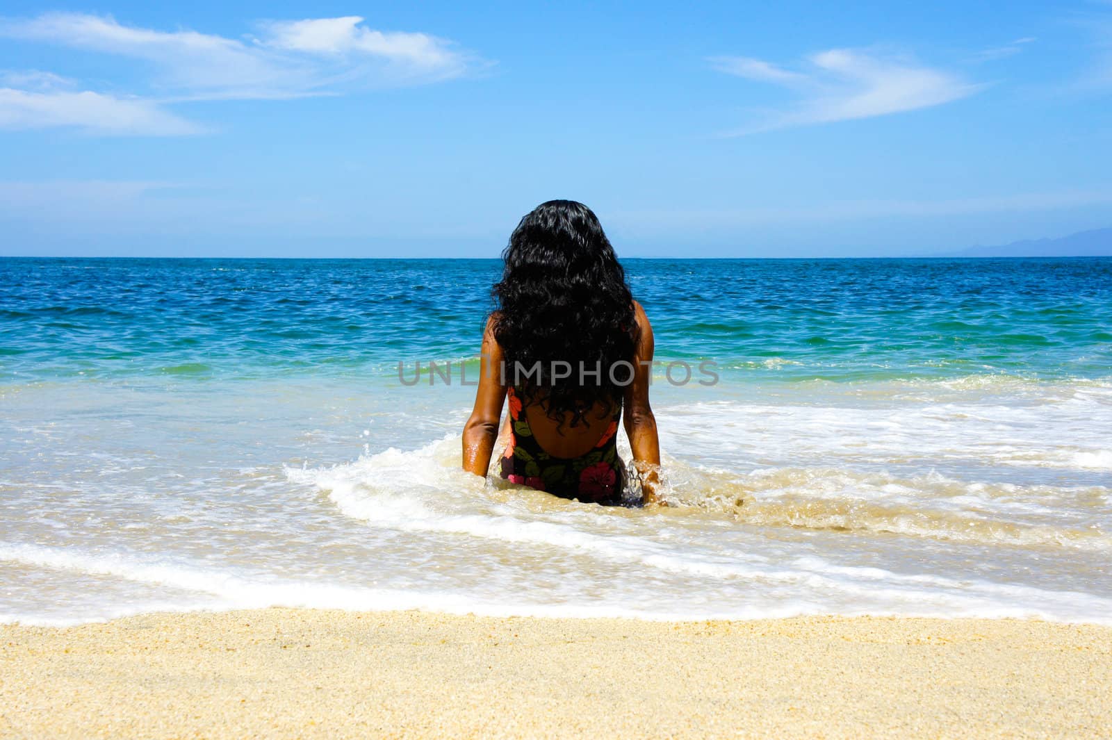 Latin Woman relaxing in the waves on the beach of Puerto Vallarta.