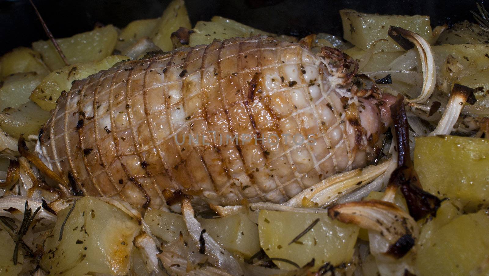 Stuffed chicken breast rolled with baked potatoes and onions.