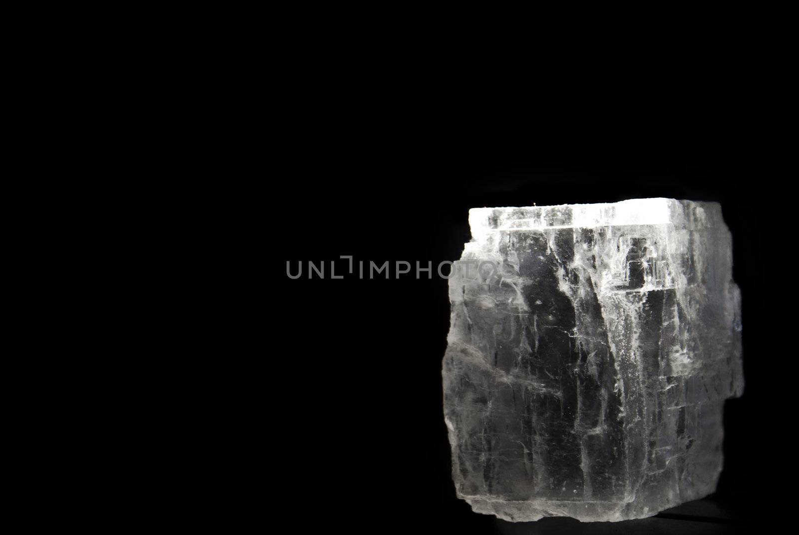 Block of rock salt mineral over black