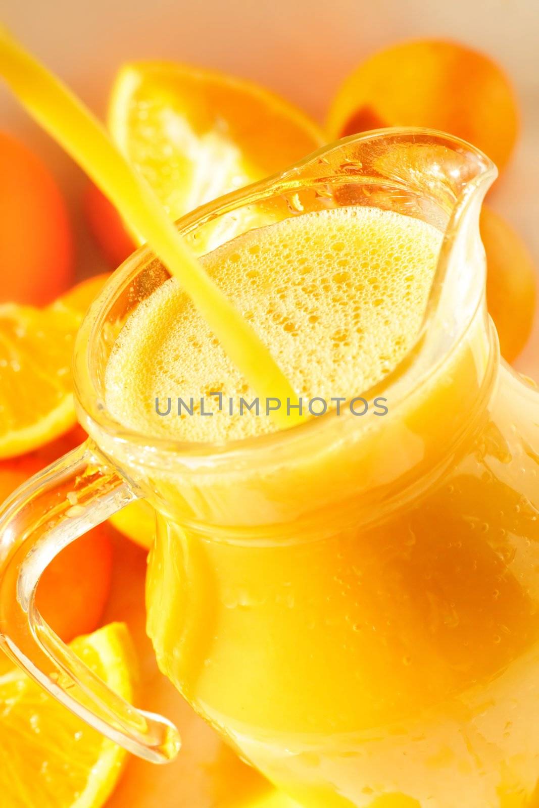 A glass of orange juice with oranges around it and a refrshing splash