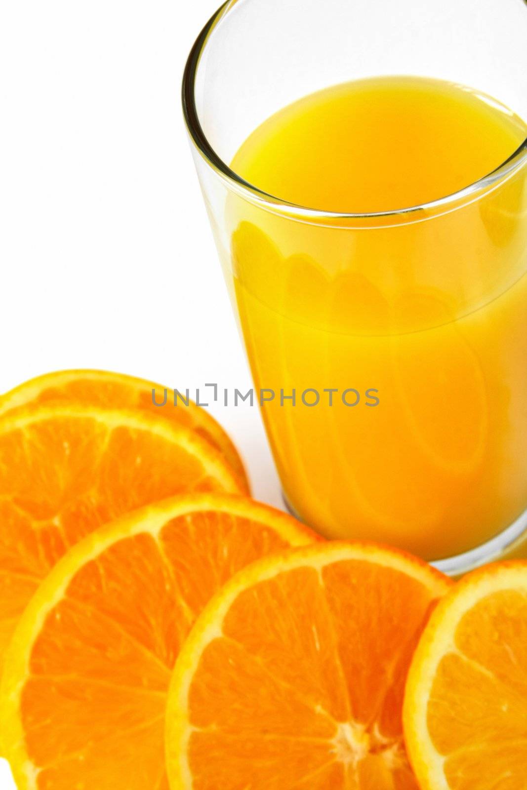 A glass of orange juice with oranges around it