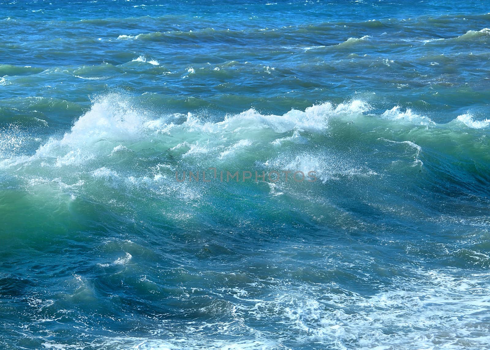 Blue ocean wave with sparkles and foam