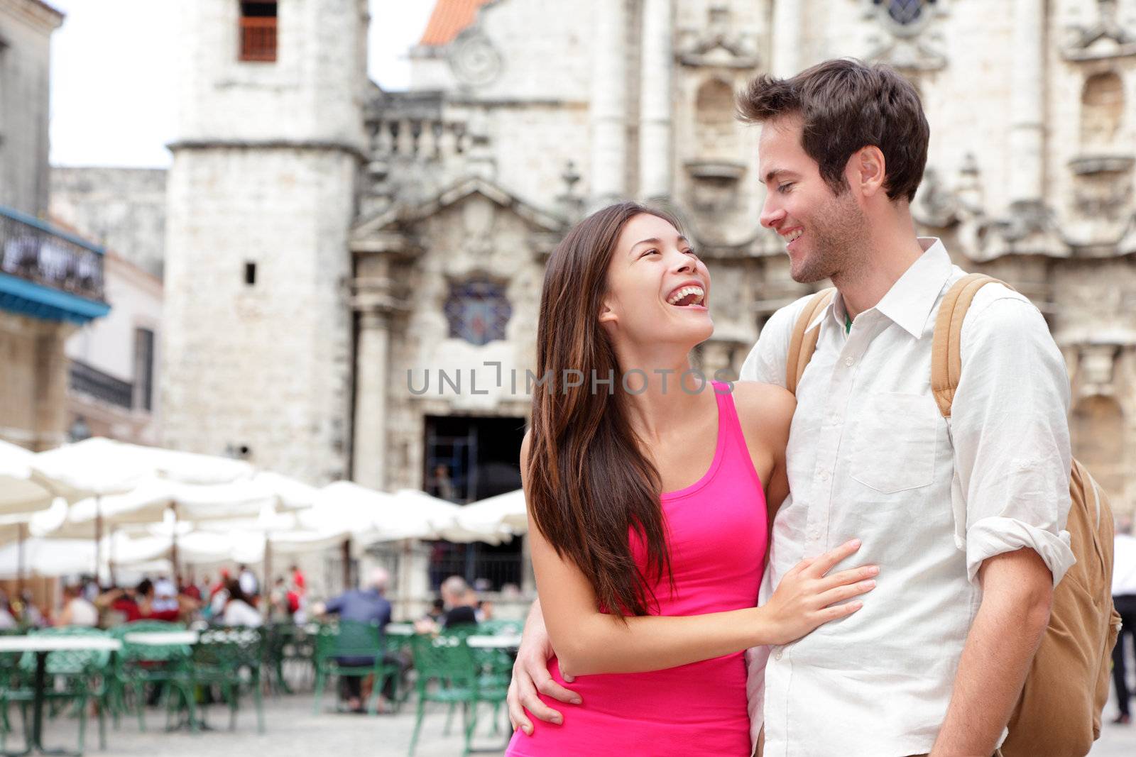 Tourists - happy couple in Cuba. Havana having fun during travel. Young interracial couple, Asian woman, Caucasian man, Plaza de la Catedral, Old Havana.