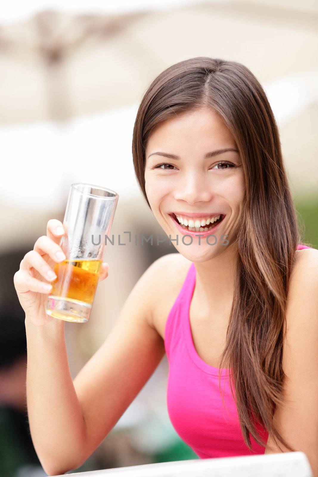 Happy cafe woman drinking alcoholic drink smiling happy looking at camera. Young mixed race Asian / Caucasian female model drinking cuban rum on sidewalk cafe in Havana, Cuba.