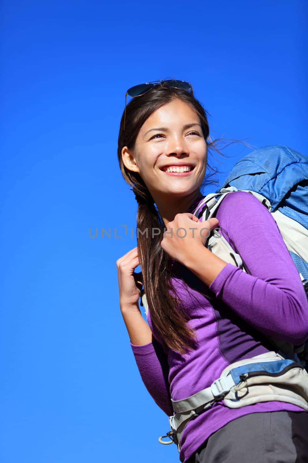 Hiker portrait. Woman hiking outdoors smiling happy and aspirational. Beautiful young mixed race Caucasian / Asian female model during hike travel.