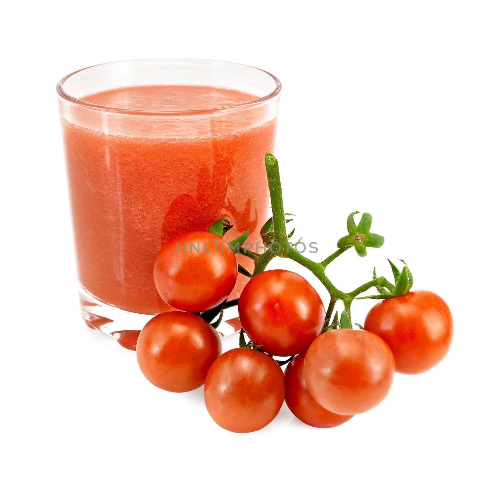 Tomato juice in low broad glass with a cluster of small tomatoes isolated on white background
