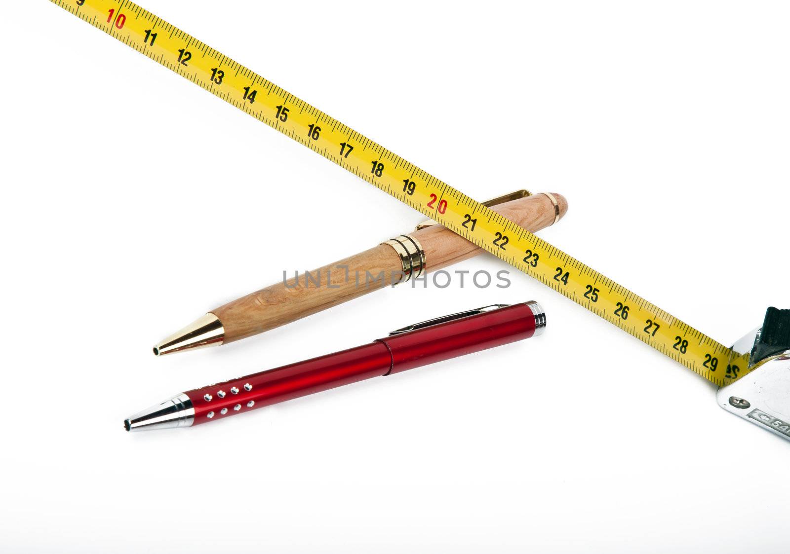 two pens and yellow measuring tape on white