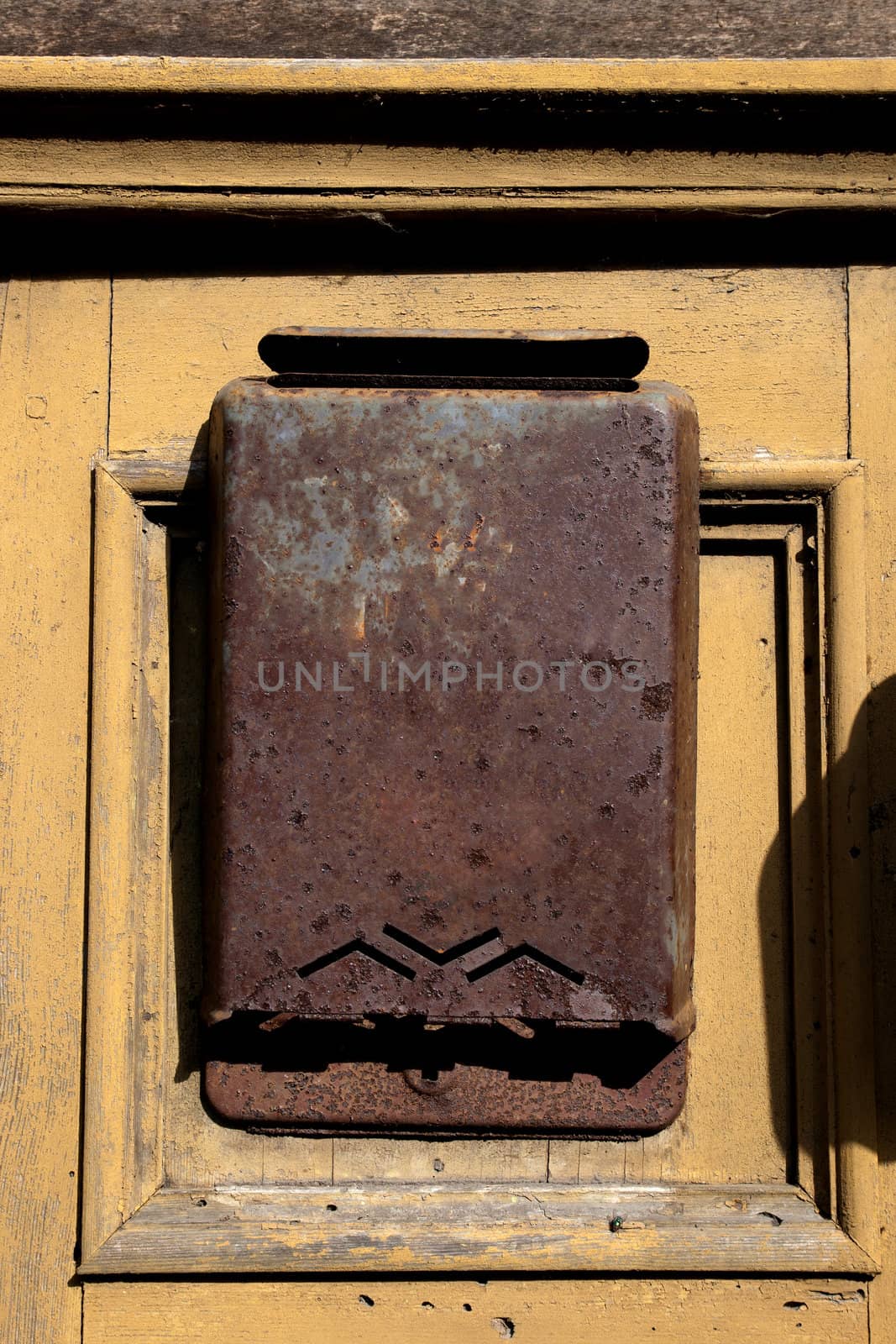 old rusty metal letter box to a wooden door
