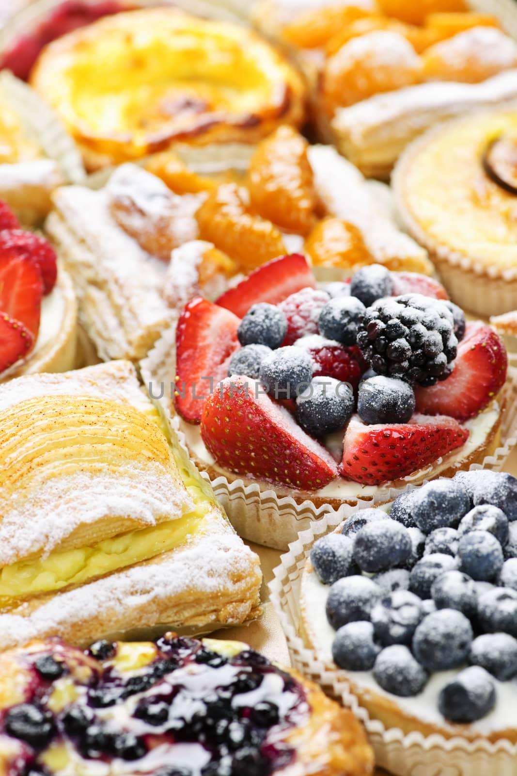 Background of assorted fresh sweet tarts and pastries