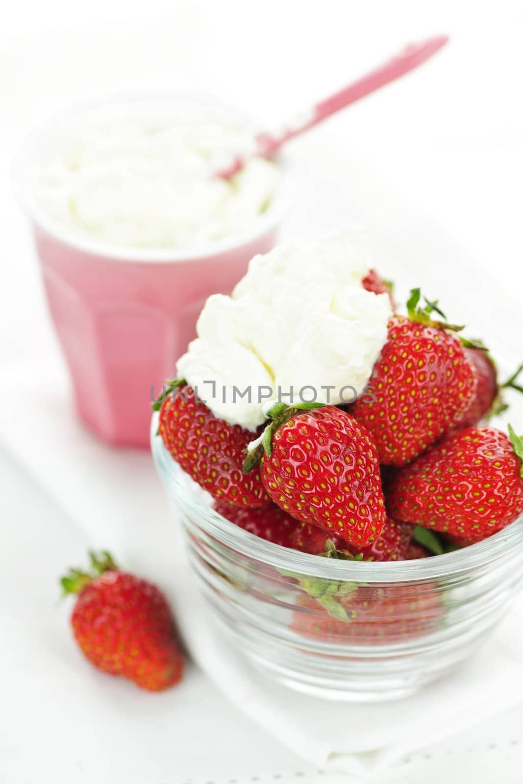 Bowl of strawberries with whipped cream by elenathewise