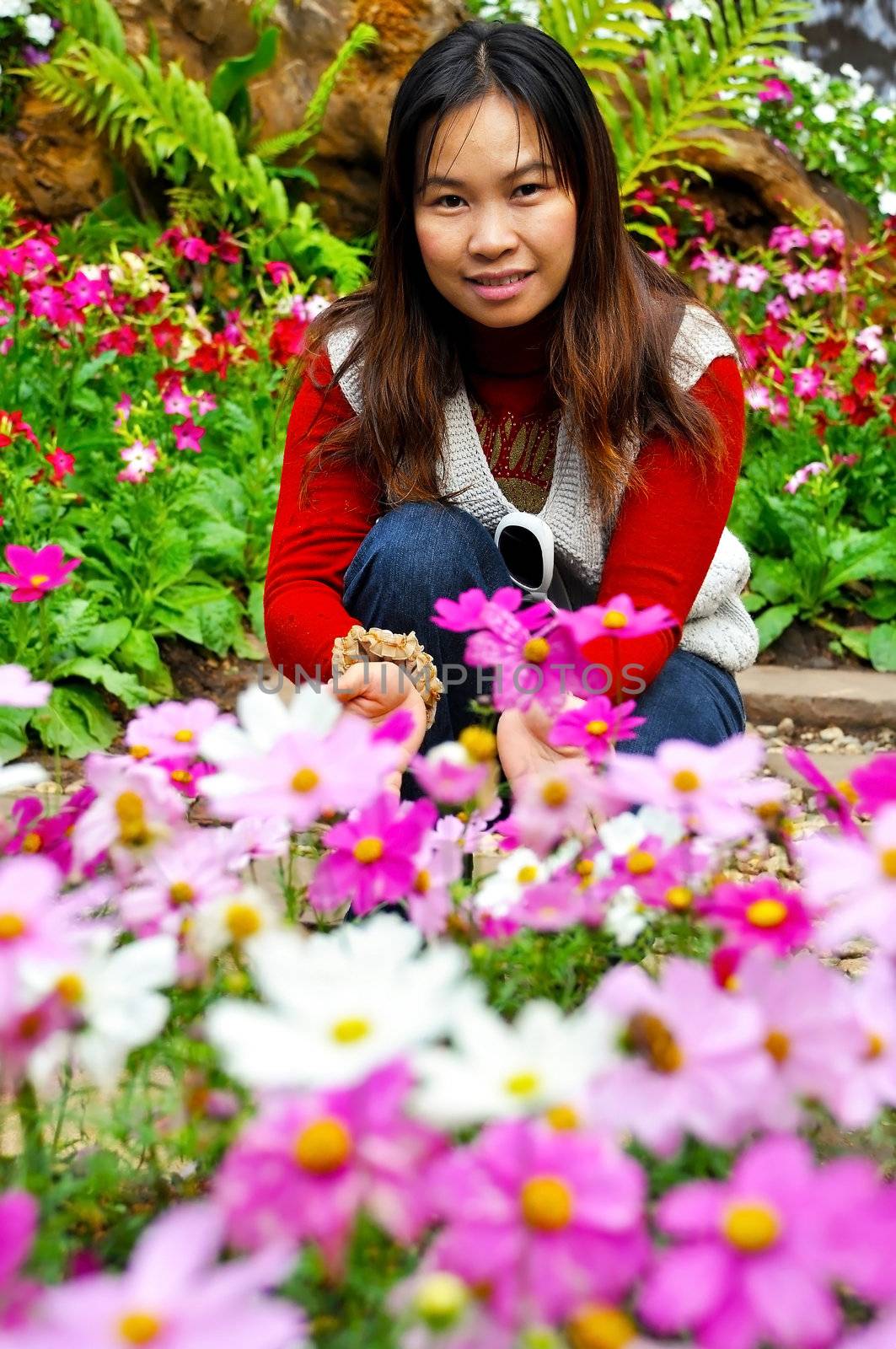 Asian woman smelling a flower in the garden by Yuri2012