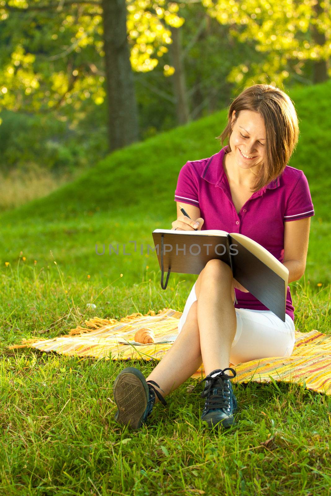 Beautiful woman laughing and writing in her diary
