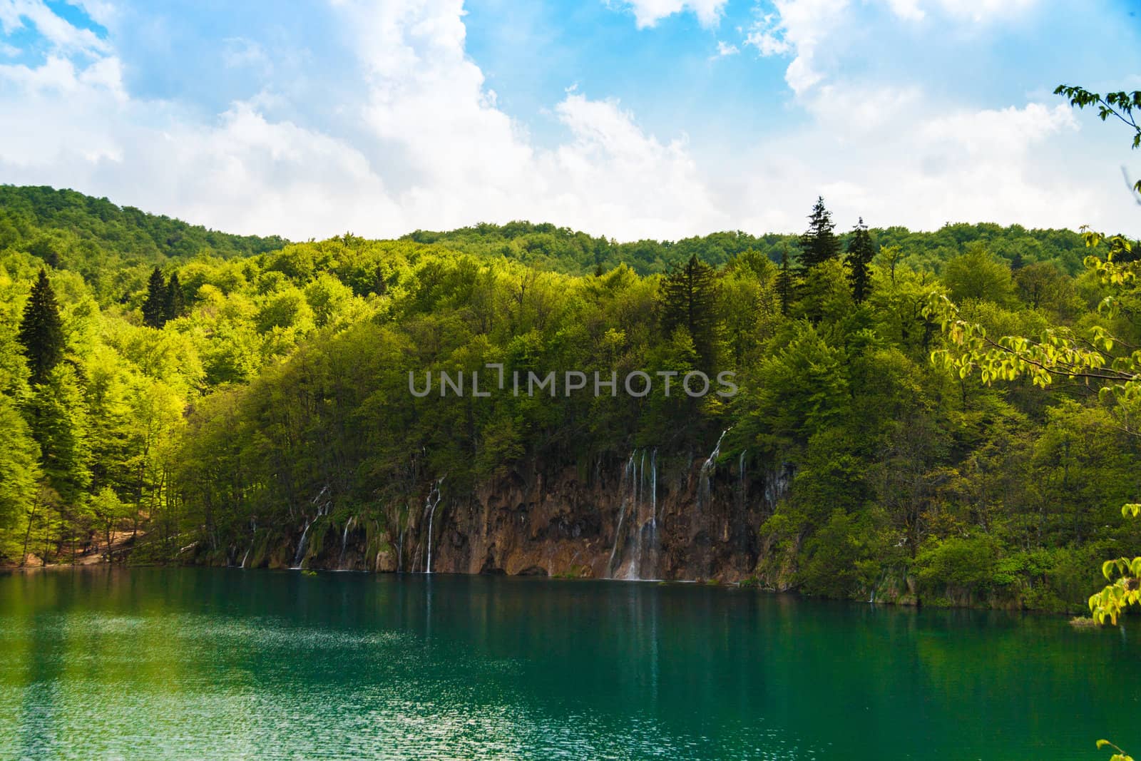Forest waterfalls with lake and clouds, shot at Plitvice lakes national park, Croatia