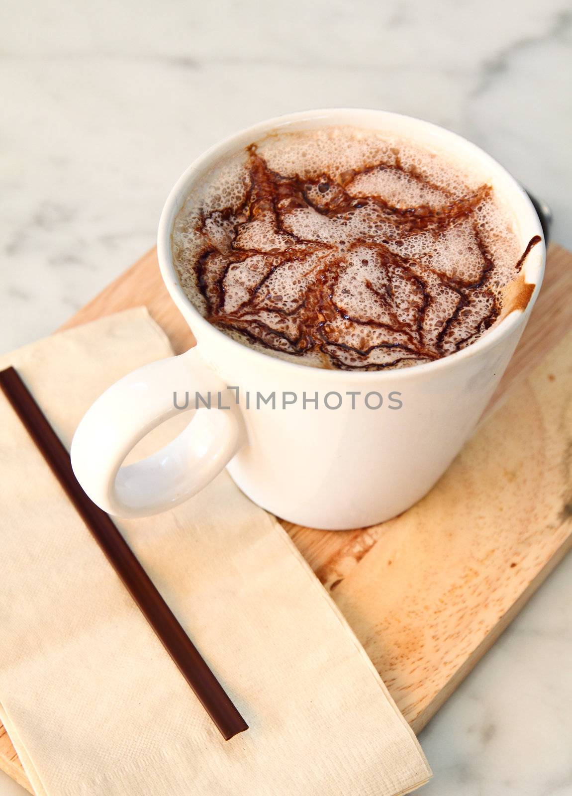 Hot chocolate with syrup on chopping board
