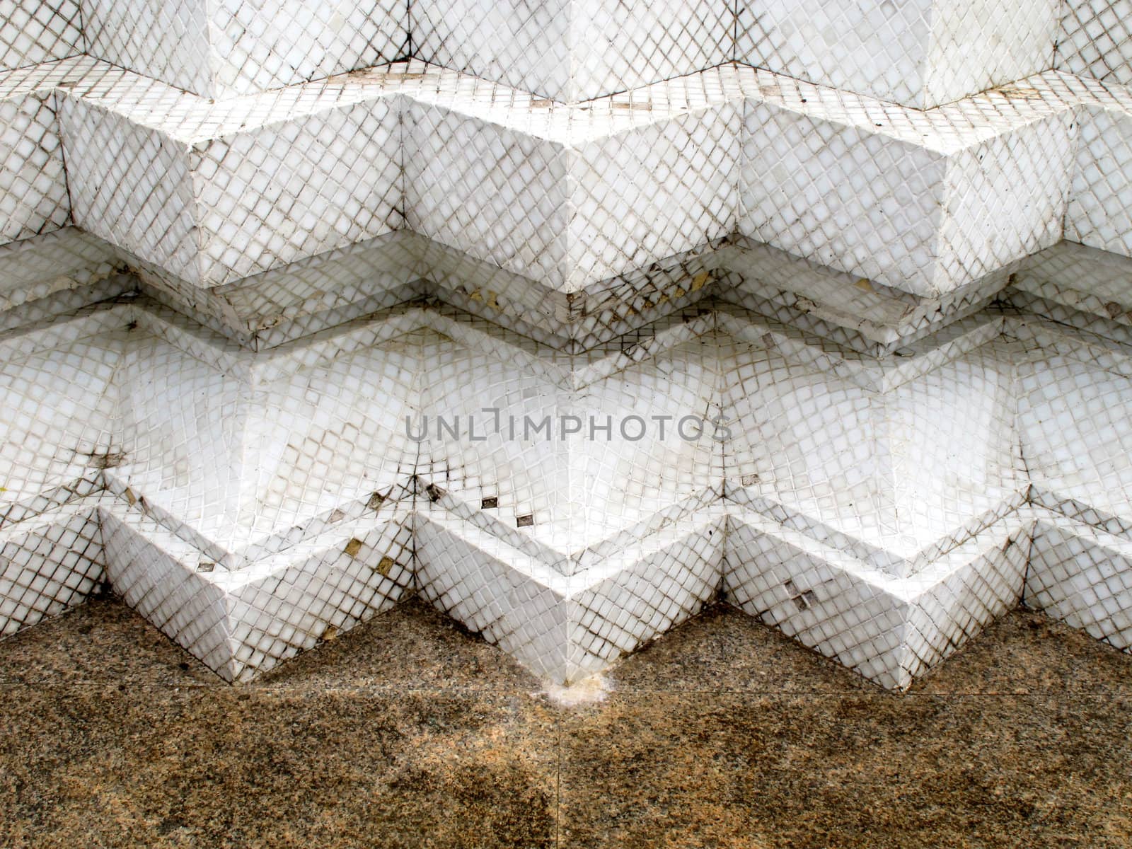 Old white serration wall on granite floor