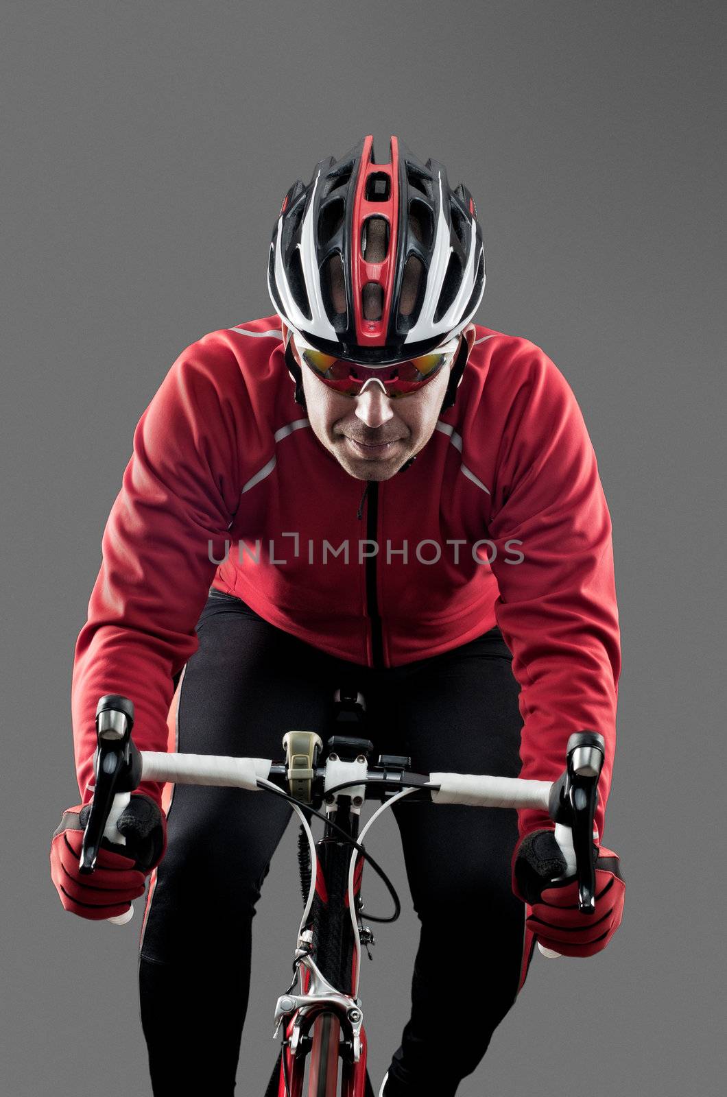 Cyclist on road bike on grey background.