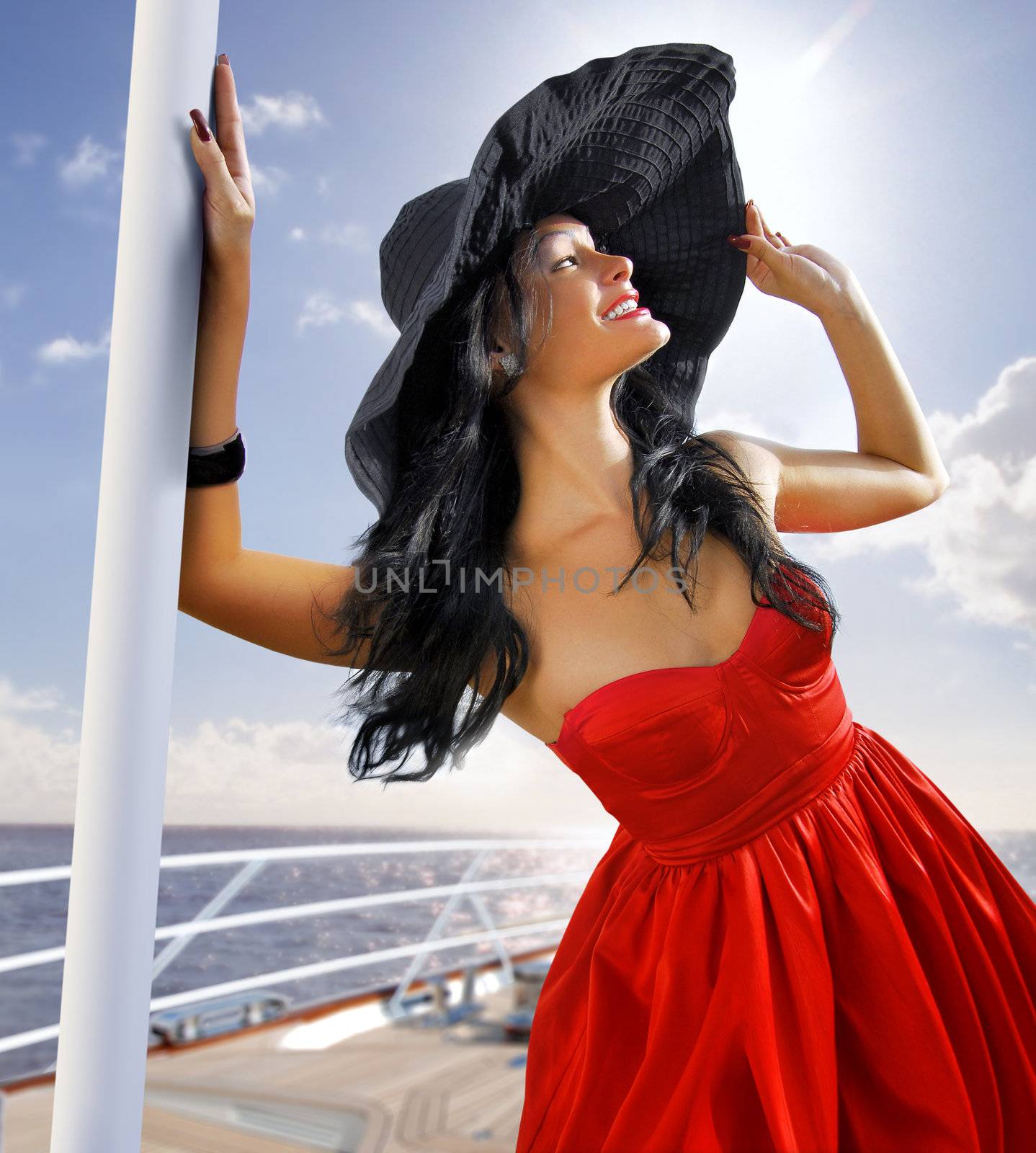 beautiful woman in black bonnet on the yacht near a shore