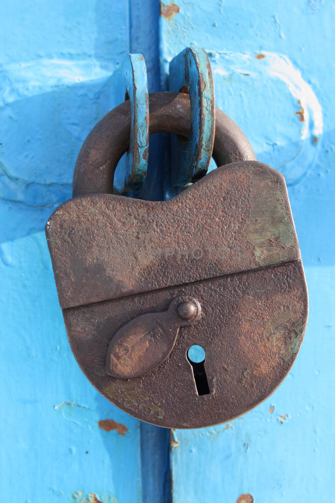 Rustic old padlock on blue background