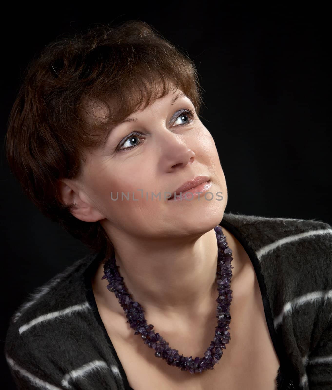 The woman of middle age with  beads on a black background