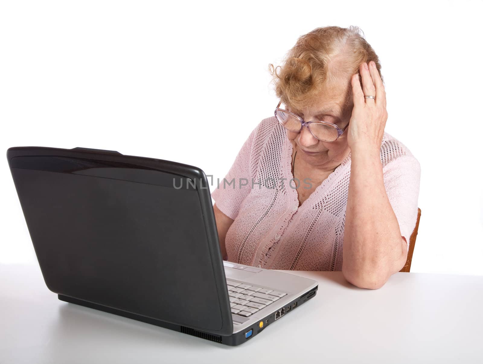 The old woman in glasses looks at the screen notebook on a white background