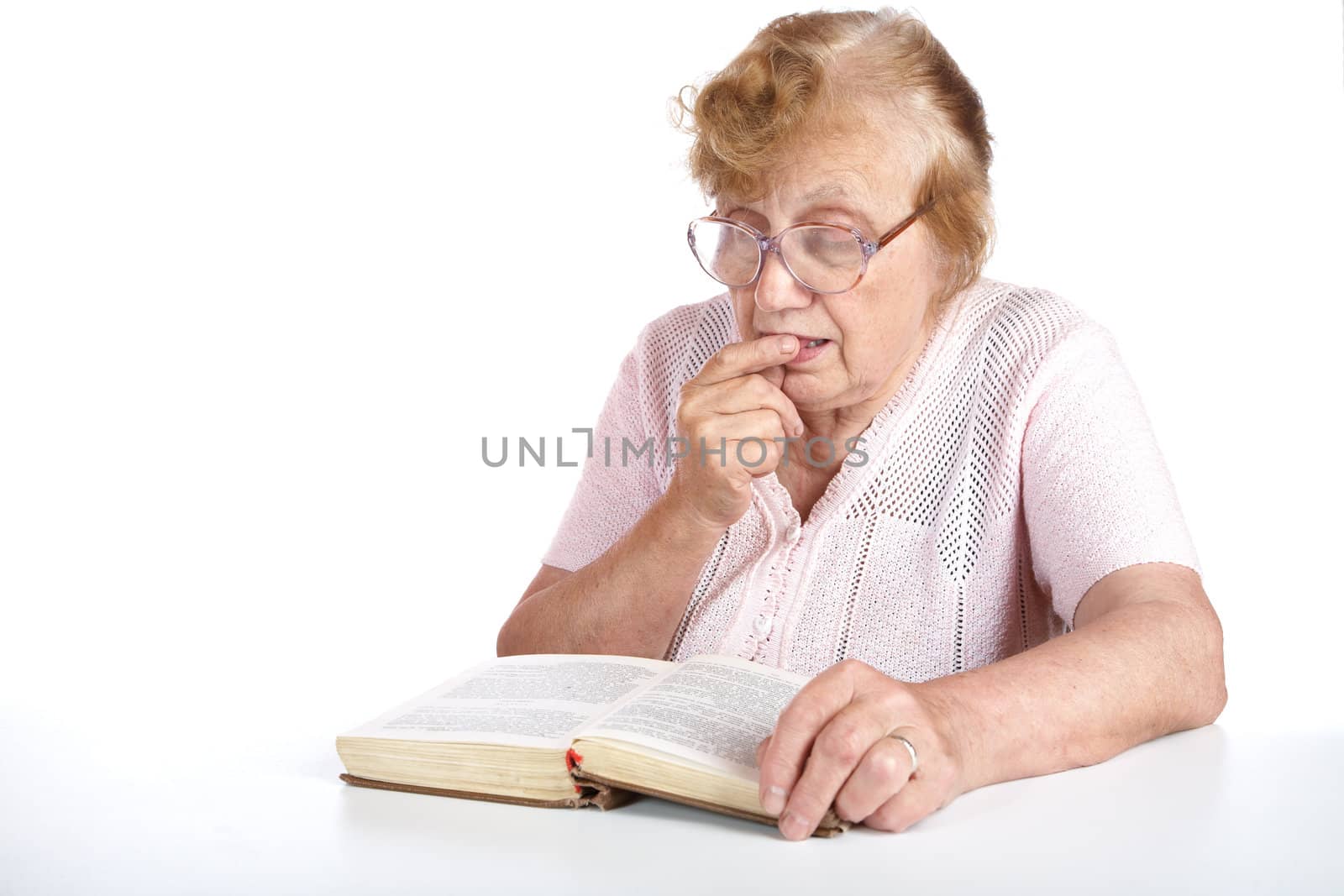 old woman in glasses reads the book on a white background