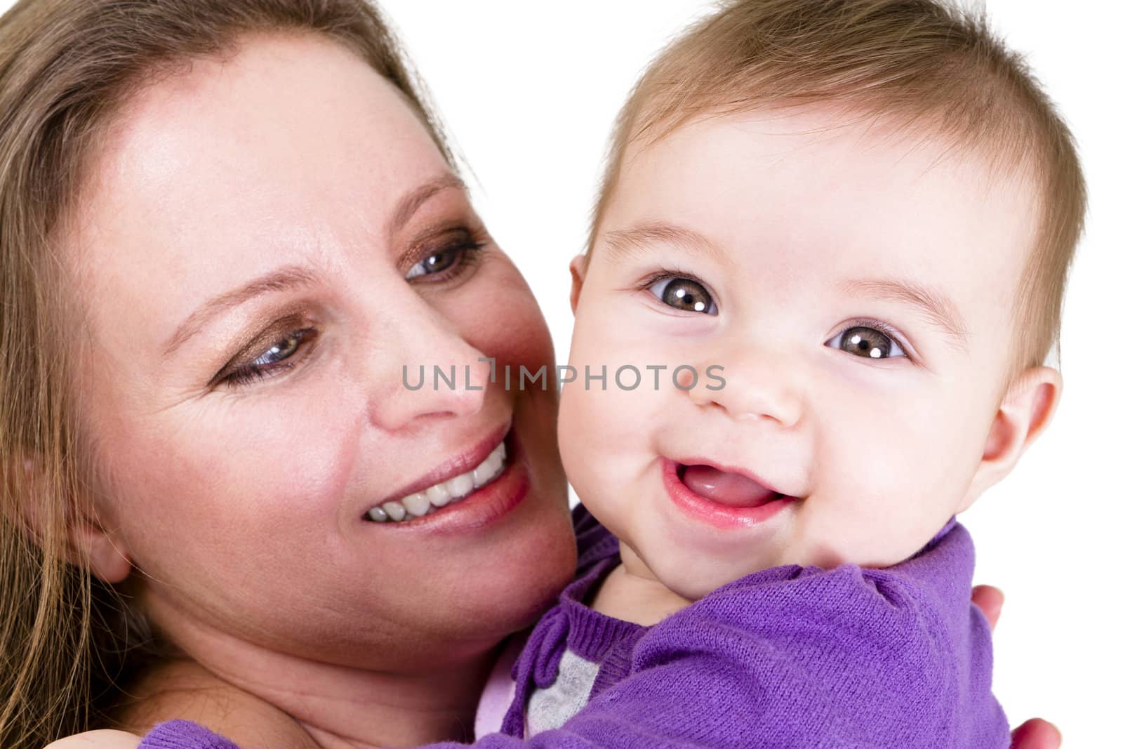 Proud mother looking at  smiling eight months old baby. Baby have a surprized happy look.