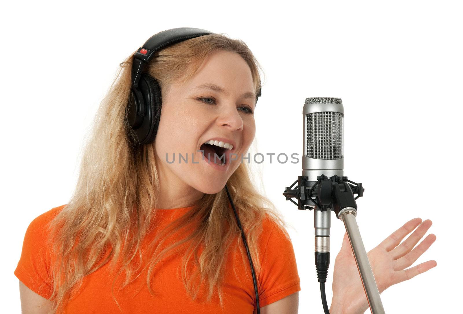 Female singer in headphones singing with the microphone. Isolated on white background.