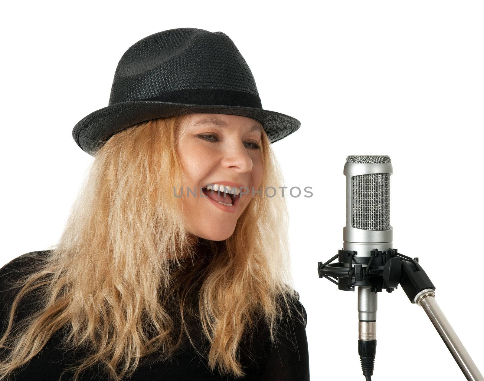 Female singer in black hat singing with studio microphone. Isolated on white background.