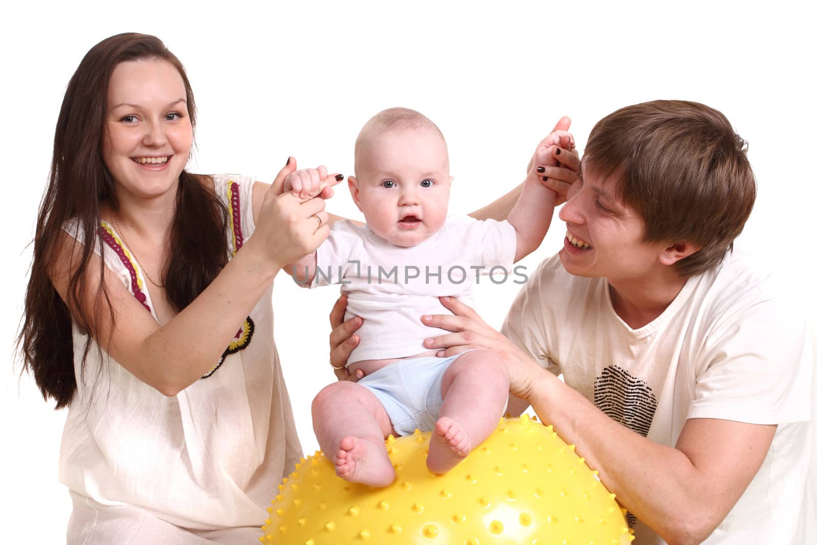 Portrait of a young family on a white background. The father, mum and the kid. A horizontal format. The kid sits on a yellow ball, parents hold it for hands.