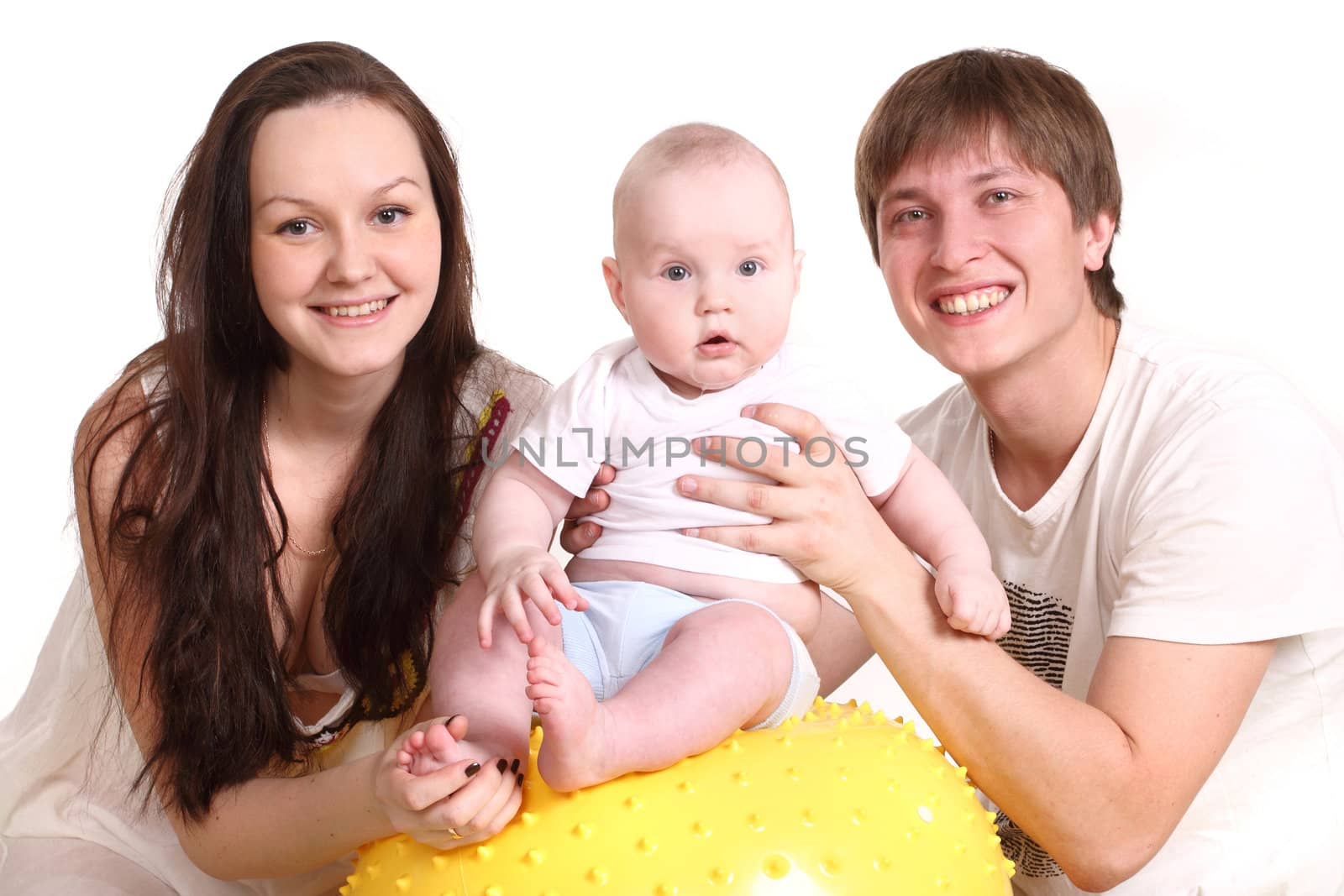 Portrait of a young family on a white background. The father, mum and the kid. A horizontal. The kid sits on a yellow ball