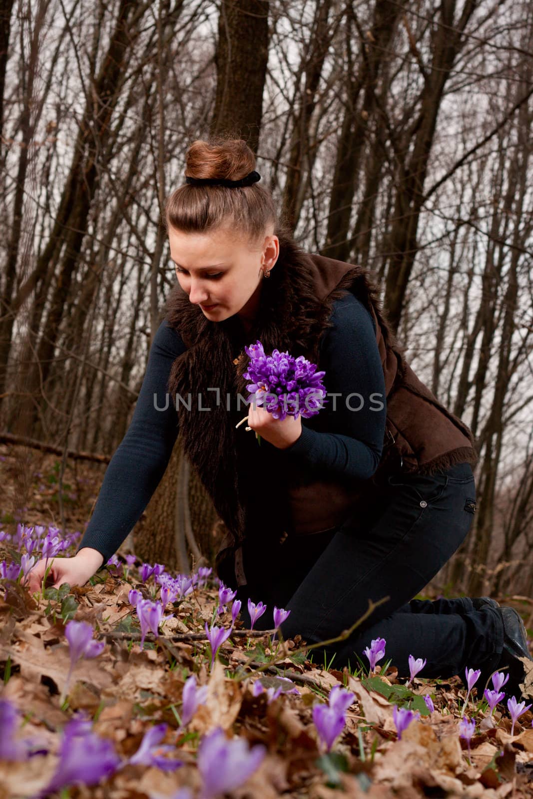 beautiful girl with snowdrops in a forest