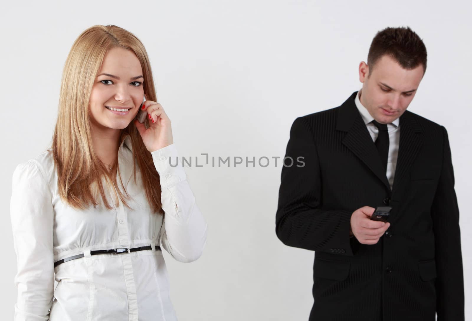 Young couple using mobile phones.Selective focus on the blonde woman.