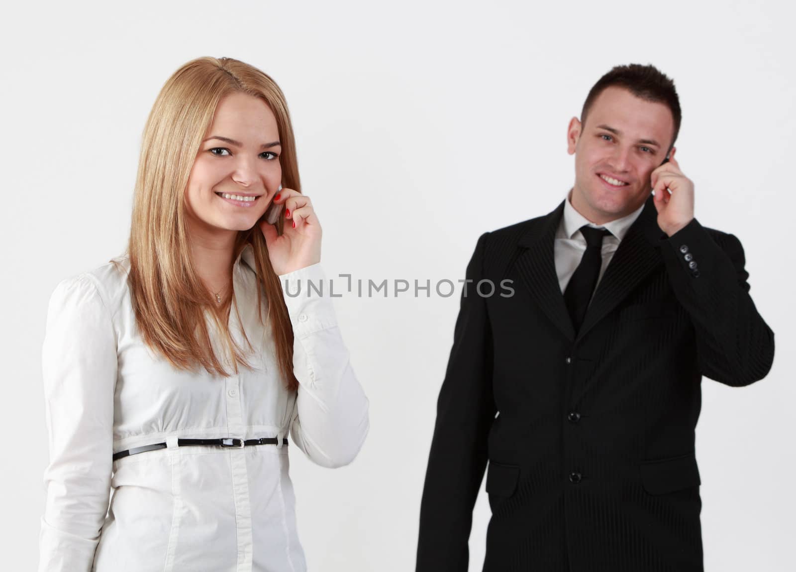 Young couple using mobile phones.Selective focus on the blonde woman.