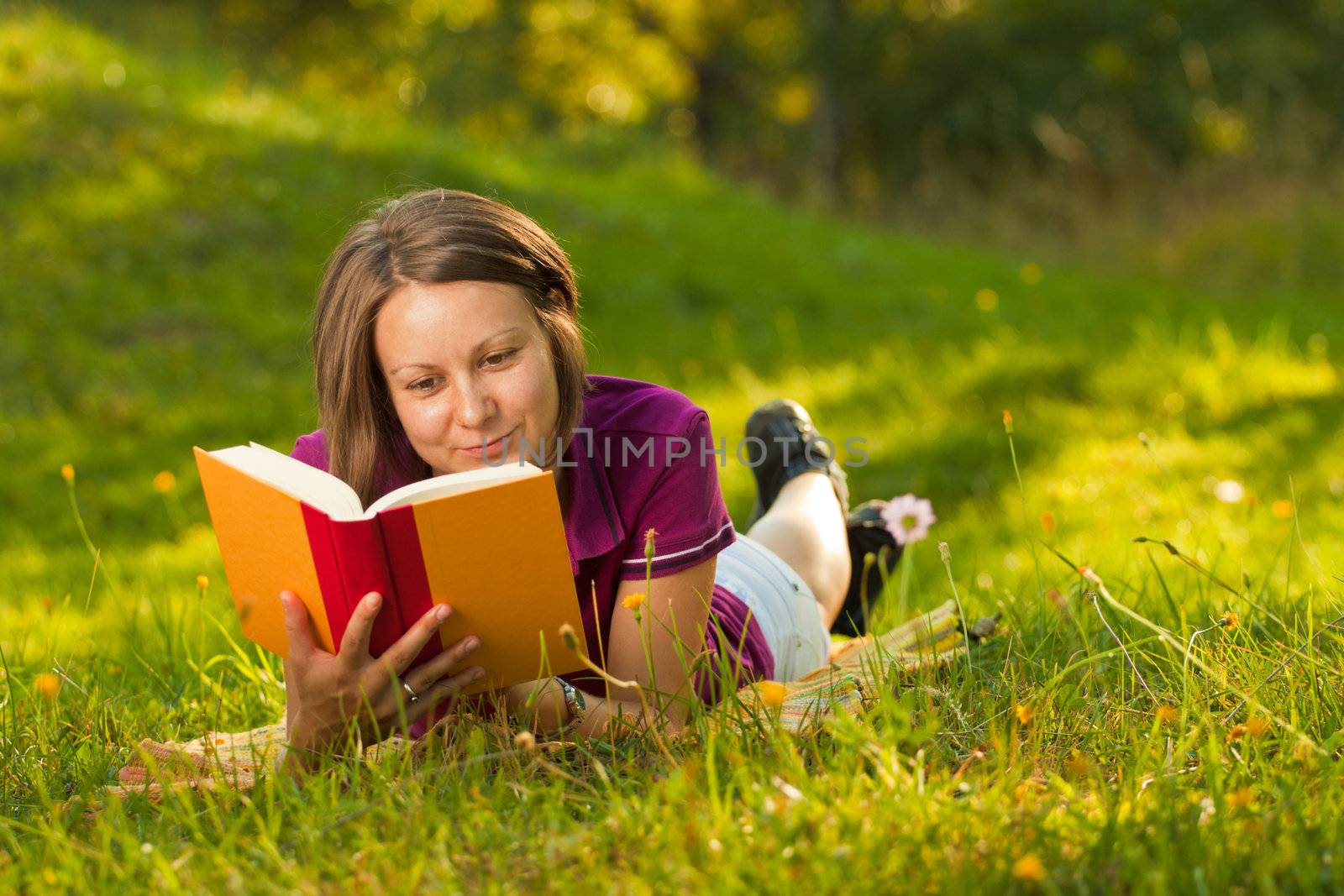 Beautiful woman with a book in the park