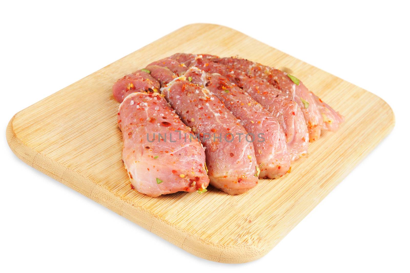 Raw meat, with spices on wooden board. Isolated on white.