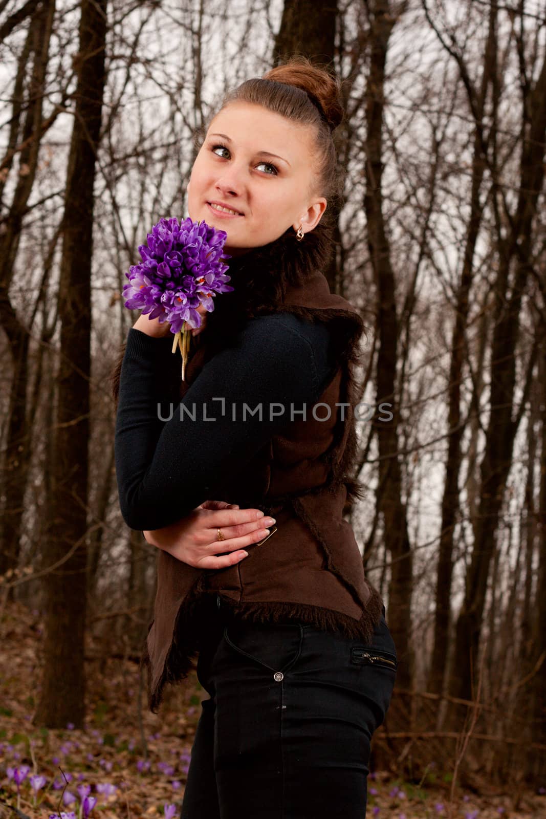 beautiful girl with snowdrops in a forest