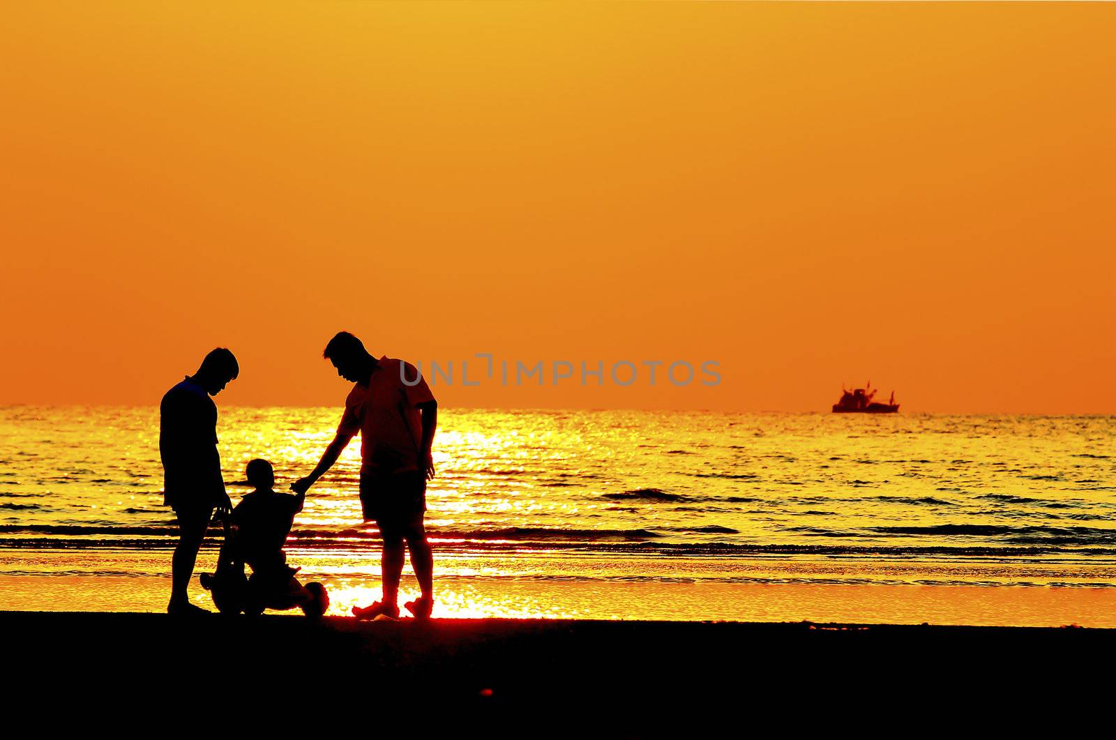 Silhouette image of father  child by the sea shore, sunset